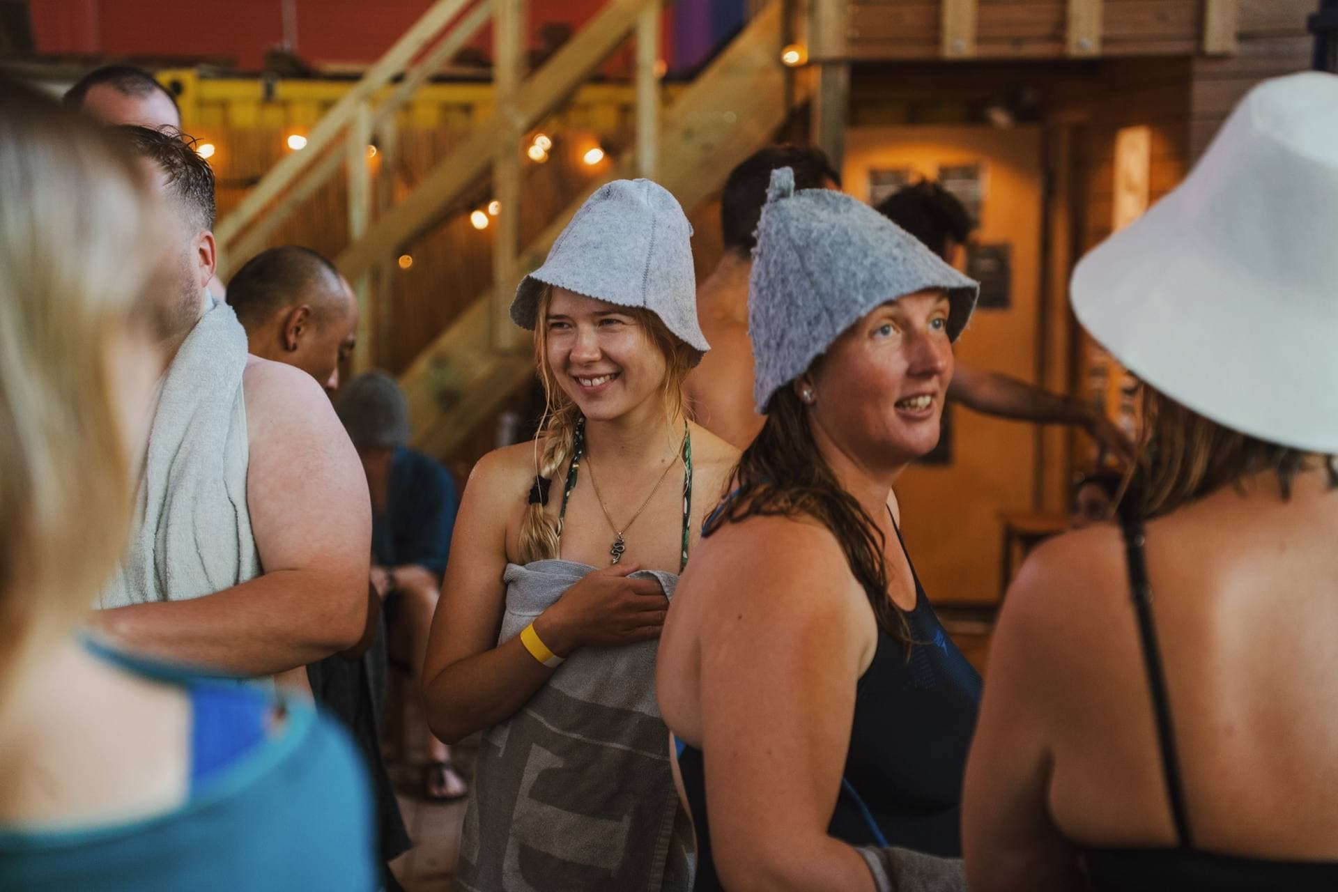 Guests in felt sauna hats laughing together