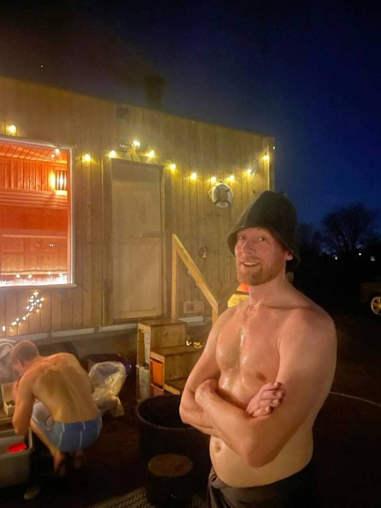 A guest in a wool sauna hat outside the sauna