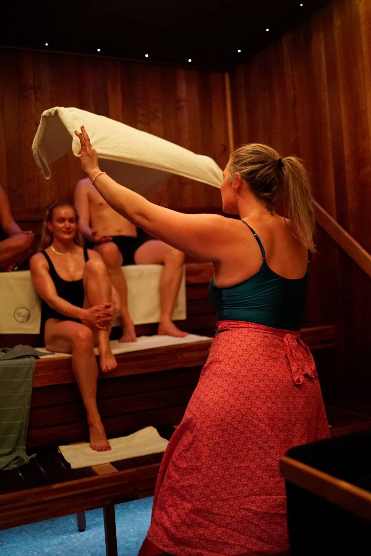A gusmester swinging the towel in front of the benches